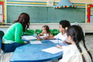 Teacher helping children with math