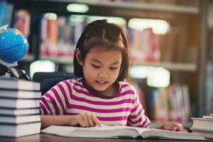 Girl reading a book in a library