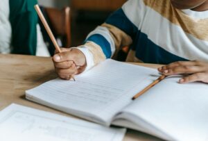 Kid writing sentences in a notebook
