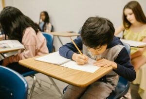 School boy writing in class