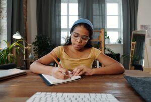 Girl writing on desk at home