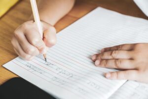 hands writing in a notebook